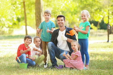 Fototapeta premium Group of children with teacher in park on sunny day
