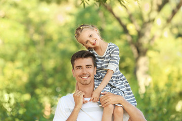 Father with daughter in park on sunny day