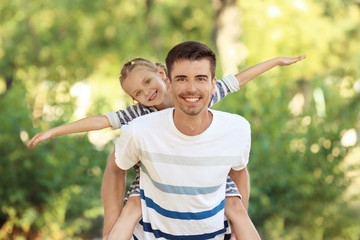 Father with daughter in park on sunny day