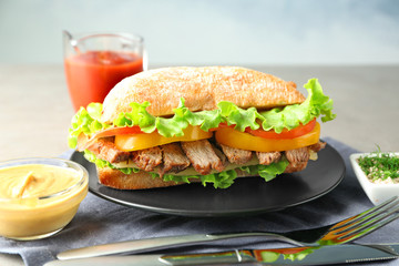 Plate with steak sandwich on table