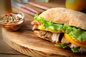 Tasty steak sandwich on wooden board