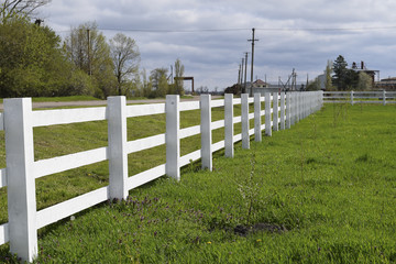 Fototapeta na wymiar White wooden fence around the ranch