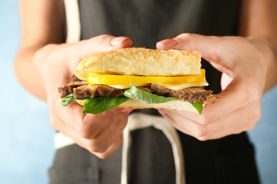Woman holding steak sandwich, closeup