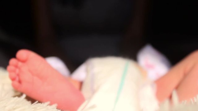 Baby feet in mother hands. Tiny Newborn Baby's feet on female Heart Shaped hands closeup. Mom and her Child. Happy Family concept. Beautiful conceptual video of Maternity.
