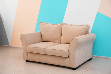 Comfortable sofa near color wall