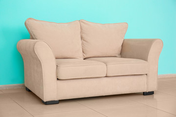 Comfortable sofa near color wall