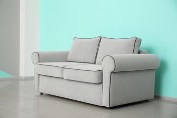 Comfortable sofa near color wall