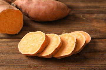 Slices of sweet potato on wooden background