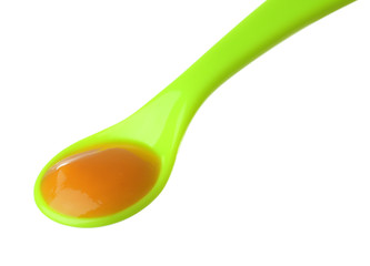 Plastic spoon with baby food on white background