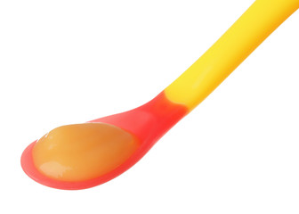 Plastic spoon with baby food on white background