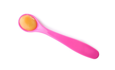 Plastic spoon with baby food on white background