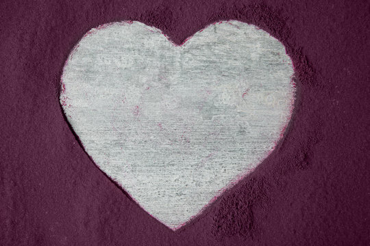 Heart-shaped frame made from acai powder on grey background
