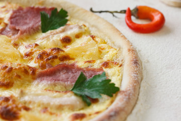Italian pizza with ham, cheese, pineapple and pepper. Delicious pizza in flour background