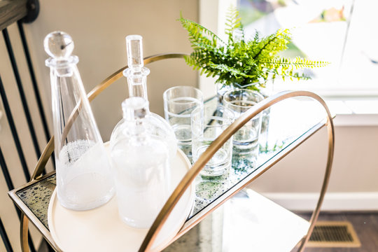 Macro closeup of serving tray stand with empty glasses and plant in staging model house, home or apartment
