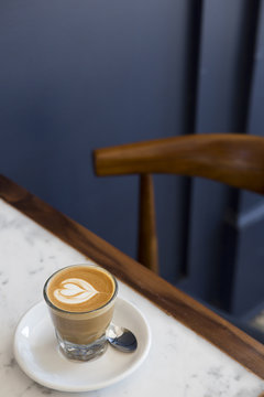 Cortado coffee on table with blue wall in background