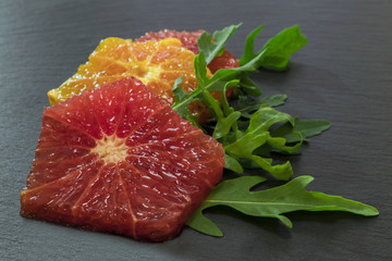 Rocket salad with oranges and grapefruit on a blue plate