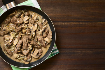 Beef Stroganoff in frying pan, a dish made of pieces of beef, mushroom and onion in cream sauce,...