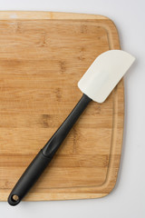 Silicone Spatula Angled on Wooden Cutting Board on White Background