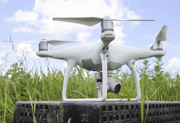 Naklejka na ściany i meble Quadrocopters on a plastic box in the grass