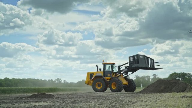 Agricultural machinery working on farming field. Agricultural equipment for loading and transporting haystacks. Haystacks in agricultural field. Farming industry