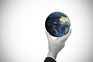 Composite image of businessman pointing little earth with his