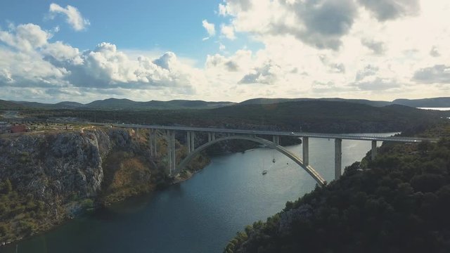 Aerial panorama view with bridge and sea around islands. Beautiful landscape surrounded with blue sea with bridge between. Autostrada bridge with traffic over Krka river at sunny day in Croatia.
