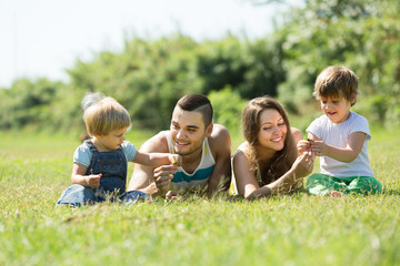 Family of four in grass at park