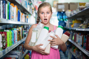 Young girl holding shampoo and shower gel