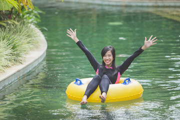 attractive asian woman relaxing at river pool