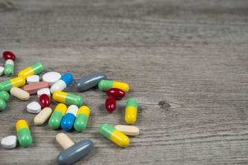 Pill background on a wood table that spilling out of pill bottle.