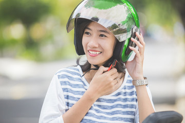 Fototapeta na wymiar woman fastening her motorbike helmet