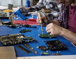 Hand soldering tin on electronics circuit board - obrazy, fototapety, plakaty