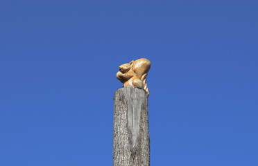 Figurine squirrel with a nut from a tree on a tree stump on a ba