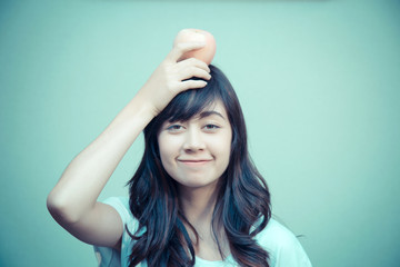 Portrait of young woman with apple on head. concept for healthy care