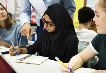 Teacher helping his students in a classroom