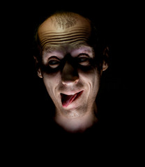 Stylish dark humorous portrait of adult caucasian man who smiles like crazy and sticks out his tongue.