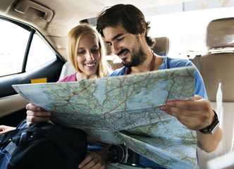 Man holding a map showing her girlfriend their next stop