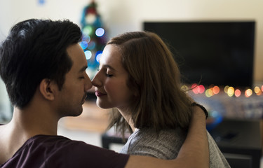 Naklejka premium Couple kissing in the sofa at home