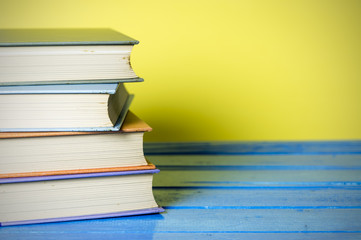 Closeup hardcover book isolated on yellow background. Selective focus.