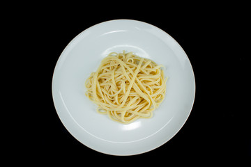 pasta spaghetti in a dish white on Black color background.Top view