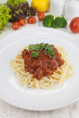 Pasta, macaroni and tomato sauce on a white dish are delicious. Put on a white wooden table.