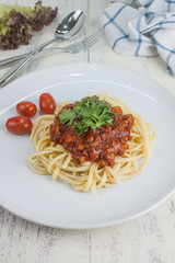 Pasta, macaroni and tomato sauce on a white dish are delicious. Put on a white wooden table.