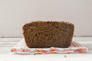 Fresh bread in the incision lies on a wooden table. Cakes from rye flou