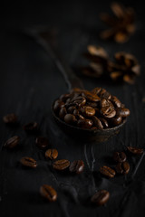 coffee beans in a vintage spoon on black background,angle view