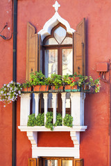 Fototapeta na wymiar Colorful small, brightly painted houses on the island of Burano,decorative window, Venice, Italy