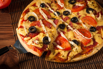 Hot pizza slice with melting cheese on a rustic wooden table