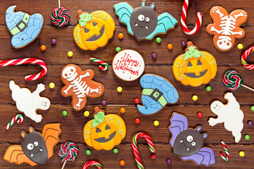 Beautiful festive background for Halloween with gingerbread, candy, autumn leaves and berries on a wooden table. Happy Halloween
