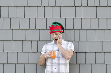 Ran out of coffee at Christmas time. Shocked man with his hand on his face holding an orange coffee mug.