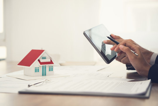 Architect team discussing floor plans and model home using tablet computer