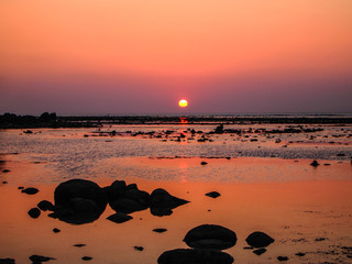 Sunset at the beach, sea ,stone ,orange sky background on Naiyang beach ,Phuket,Thailand .summer holiday concept.